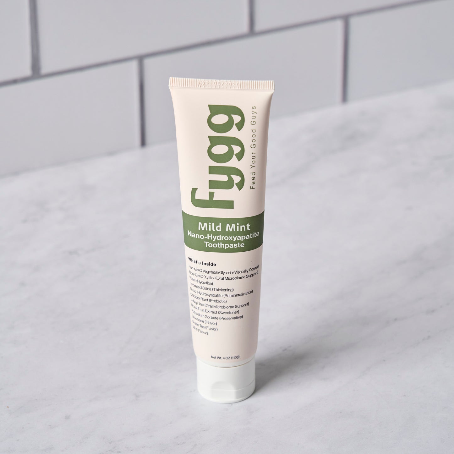 Fygg Nano-Hydroxyapatite fluoride free Toothpaste in Mild Mint with Subway Tile Background